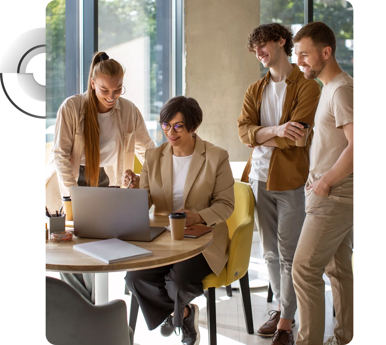 Four young leaders gathered around a laptop in a bright office